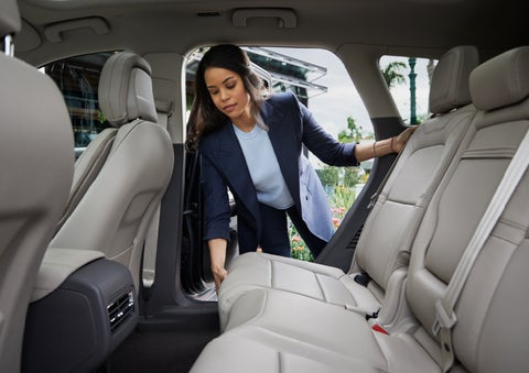 A woman slides the second-row seat forward to create more cargo space | Parkway Lincoln in Dover OH