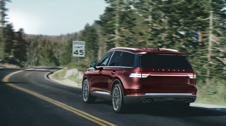A 2024 Lincoln Aviator® SUV is being driven on a winding mountain road | Parkway Lincoln in Dover OH