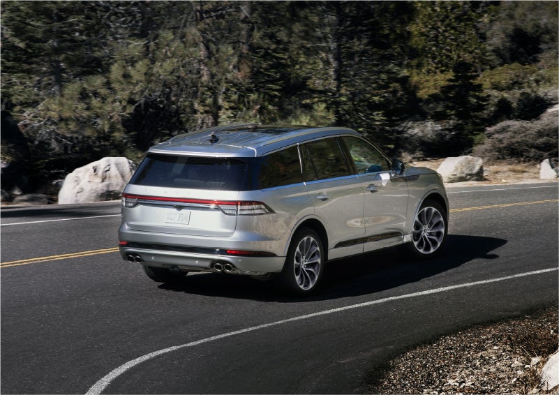 A 2023 Lincoln Aviator® Grand Touring model is shown being driven on a tight turn of a mountain road | Parkway Lincoln in Dover OH