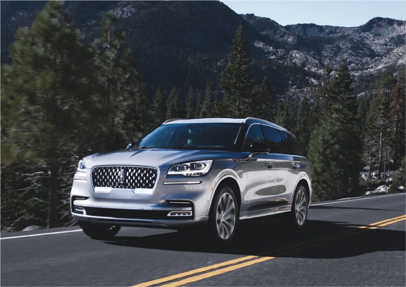 A 2023 Lincoln Aviator® Grand Touring SUV being driven on a winding road to demonstrate the capabilities of all-wheel drive | Parkway Lincoln in Dover OH